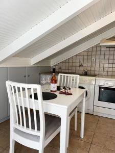 une cuisine avec une table blanche et deux chaises blanches dans l'établissement Cozy City Loft, à Argostóli