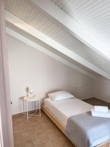 - une chambre blanche avec un lit et une table dans l'établissement Cozy City Loft, à Argostóli
