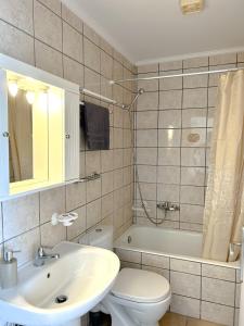 La salle de bains est pourvue d'un lavabo, de toilettes et d'une baignoire. dans l'établissement Cozy City Loft, à Argostóli