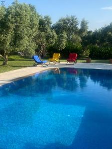 two chairs and a swimming pool with blue water at Nefes URLA Villa Sea View. in Urla