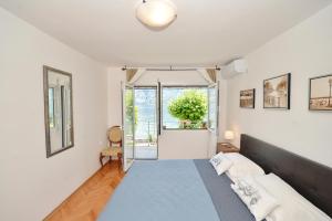 a bedroom with a bed and a large window at Apartments Ivanović in Kotor