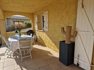 a table and chairs in a room with a cactus at Appart'O Soleil in Fréjus