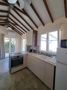 cocina grande con armarios blancos y ventana grande en Sunset Retreat Cyprus, en Pendakomo
