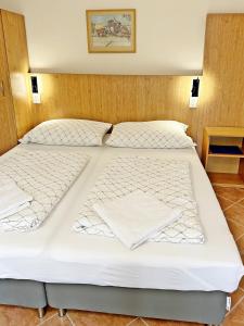 two beds in a hotel room with white sheets at Süle Apartments & Rooms in Balatonfüred