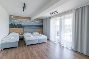 1 dormitorio con 2 camas y un cuadro en la pared en Apartamenty Przy Ścieżce Velo Czorsztyn, en Dębno
