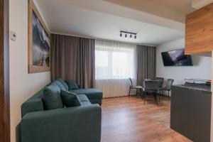 ein Wohnzimmer mit einem Sofa und einem Tisch in der Unterkunft Apartamenty Przy Ścieżce Velo Czorsztyn in Dębno