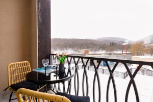 a balcony with a table with a glass of wine at hotelise l Mountain View in Tsaghkadzor