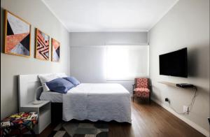 a bedroom with a bed and a tv on a wall at Castelli Studios centro SP in Sao Paulo