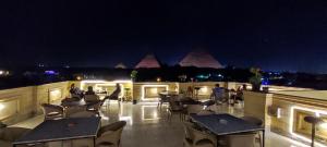 un patio con mesas y sillas por la noche en Eye of Ra - Guest house, en El Cairo