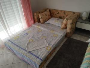 Cama pequeña en una habitación junto a una ventana en Apartment Marta, en Kali