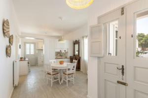 a kitchen and dining room with a white table and chairs at Citrine in Naousa