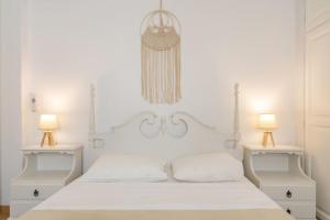 a white bedroom with a large white bed with two lamps at Citrine in Naousa