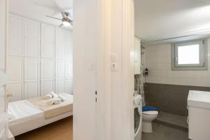 a white bathroom with a bed and a toilet at Citrine in Naousa +22 photos