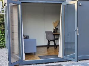 una puerta corredera de cristal en una habitación con silla en Knus vakantieverblijf voor 2 personen, en Ureterp