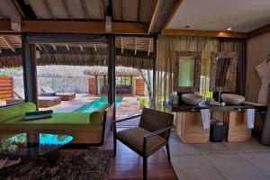 a room with a couch, chairs and a table at Hotel Kia Ora Resort & Spa in Avatoru