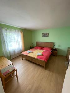 a bedroom with a large bed with a red bedspread at Pension U Rytíře in Janov
