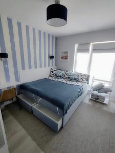 クリニツァ・モルスカにあるLuksusowy Apartament Stella - Port Krynica Morskaのベッドルーム1室(青い掛け布団付きのベッド1台付)