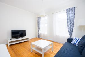 a living room with a blue couch and a tv at Ringi Apartments in Pärnu