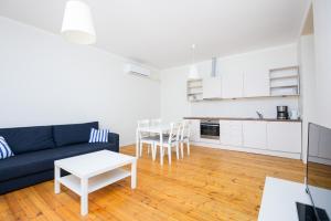 sala de estar con sofá azul y mesa en Ringi Apartments, en Pärnu