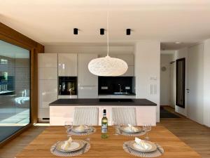 a dining room with a table and a kitchen at Seeparkvilla – Wohlfühlen am See und im Grünen in Bregenz +49 photos