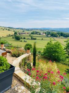 a garden with flowers and a view of a field at Mazille Les Trois Monts in Mazille