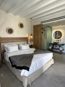 a bedroom with a large bed and a mirror at Panormos Village in Panormos Mykonos