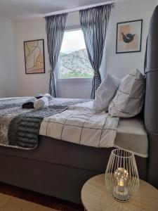 1 dormitorio con 1 cama, ventana y mesa en Apartmani 'Cvit', en Karlobag