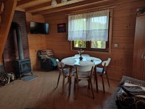 a dining room with a table and a stove at Domki Blizniaki in Żywki
