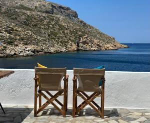 two chairs sitting on a patio looking at the ocean at Motivo Sea Side in Sifnos