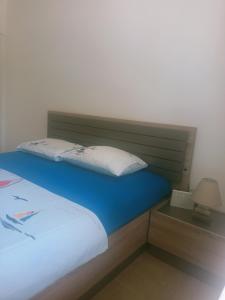 Apartman Anika في سوتوموري: غرفة نوم بسرير من اللوح الأمامي ومصباح