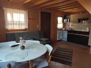 ein Wohnzimmer mit einem Tisch und einer Küche in der Unterkunft Domki Blizniaki in Żywki