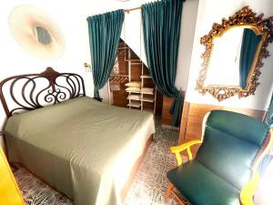 ein Schlafzimmer mit einem Bett, einem Stuhl und einem Spiegel in der Unterkunft Esmeralda Apartment With Free Private Underground Parking in Valencia