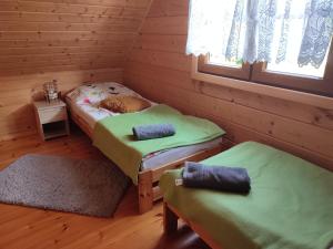 Zimmer mit 2 Betten in einem Blockhaus in der Unterkunft Domki Blizniaki in Żywki