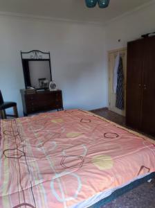 - une chambre avec un lit et une couverture rose dans l'établissement Noor Apartment, à Amman