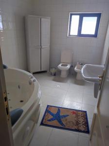 La salle de bains est pourvue d'une baignoire, de toilettes et d'un lavabo. dans l'établissement Noor Apartment, à Amman