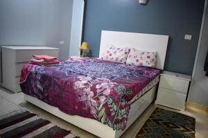 um quarto com uma cama com um cobertor roxo e almofadas em Villa Rebecca em Luxor