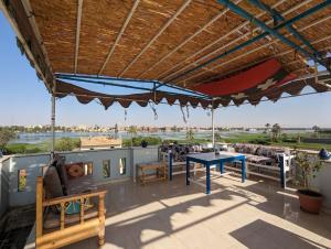 patio z niebieskim stołem i krzesłami na dachu w obiekcie Villa Rebecca w mieście Luksor