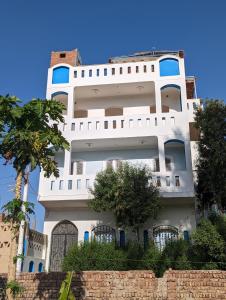a white building with trees in front of it at Villa Rebecca in Luxor