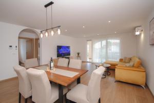 uma sala de jantar e sala de estar com mesa e cadeiras em Brand-new 3-bedroom apartments em Kaštela
