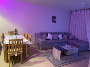 a living room with a purple couch and a table at قرية أزها العين السخنه in Ain Sokhna
