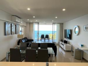 a living room with a couch and a dining room at Redvue Holiday Apartments in Redcliffe