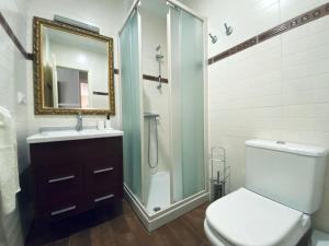 een badkamer met een douche, een toilet en een wastafel bij Apartamento centro de O Grove in O Grove