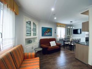 een woonkamer met een bank en een keuken bij Apartamento centro de O Grove in O Grove