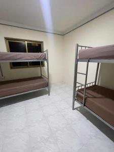 two bunk beds in a room with a tile floor at Ommi Hostel in St Julian's