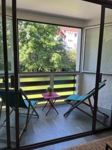 balkon z 2 krzesłami, stołem i oknem w obiekcie Grand T2 renové, plein centre, 62 m² w mieście Villard-de-Lans