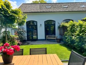 a patio with a wooden table and chairs in a yard at Nieuw Molenwijk 4-5 persoons in Oostkapelle