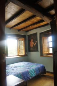 1 dormitorio con 1 cama en una habitación con ventanas en CASA EN BRAÑA VAQUEIRA EN OCCIDENTE DE ASTURIAS, 