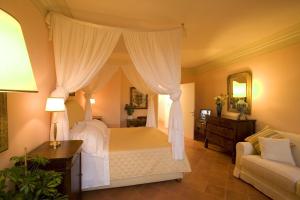 1 dormitorio con cama con dosel y sofá en Residenza d'Epoca Campo Regio Relais, en Siena