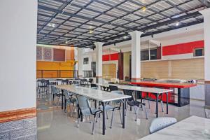 een cafetaria met tafels en stoelen in een gebouw bij OYO 92518 De Luna Hotel in Banjarbaru