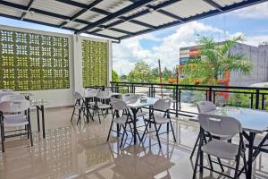 restauracja z białymi krzesłami i stołami oraz dużym oknem w obiekcie OYO 92518 De Luna Hotel w mieście Banjarbaru